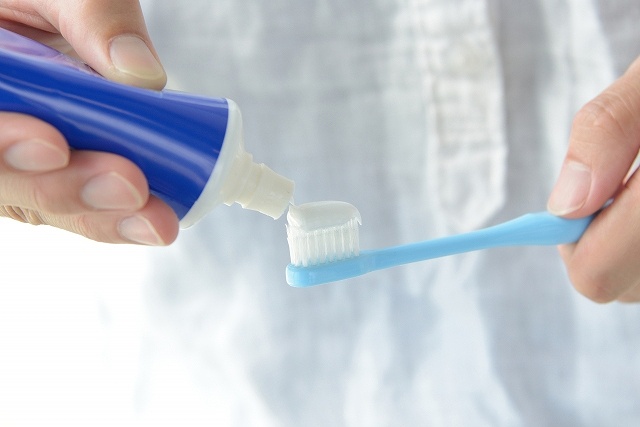 歯ブラシに歯磨き粉をつけている画像